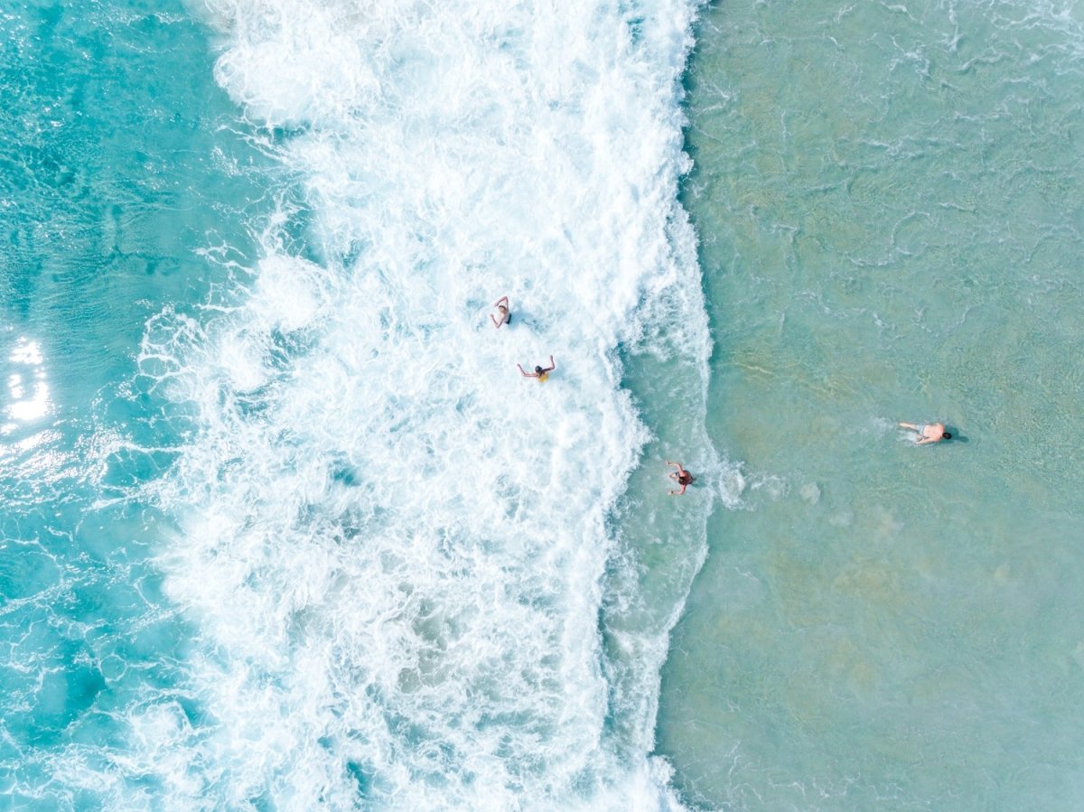 Aerial of people swimming in waves abstract drone