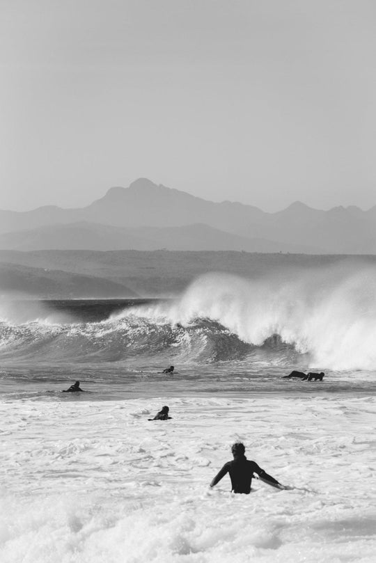 Black and white image of kids surfing in Plett