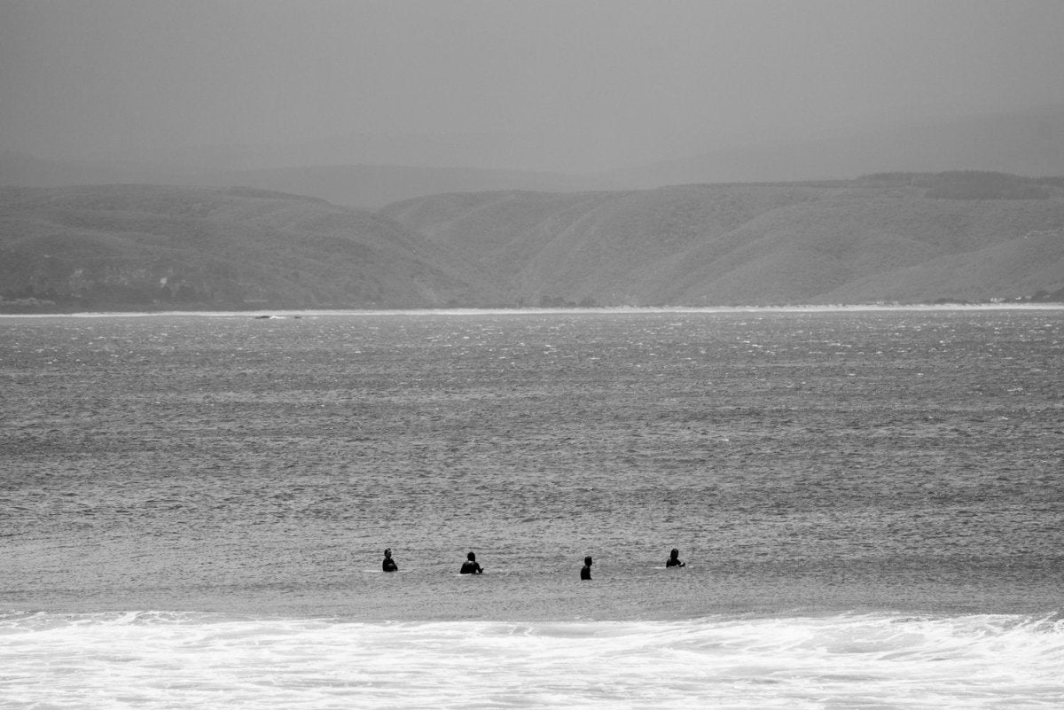 Surfers sitting at backline