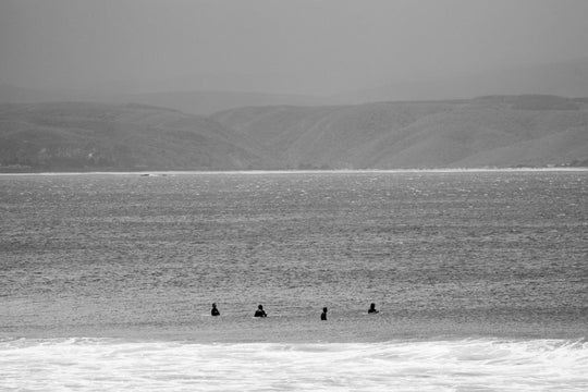 Surfers sitting at backline