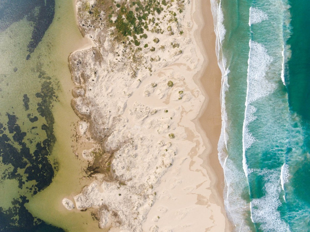 Sea waves and river divided by sandy dunes