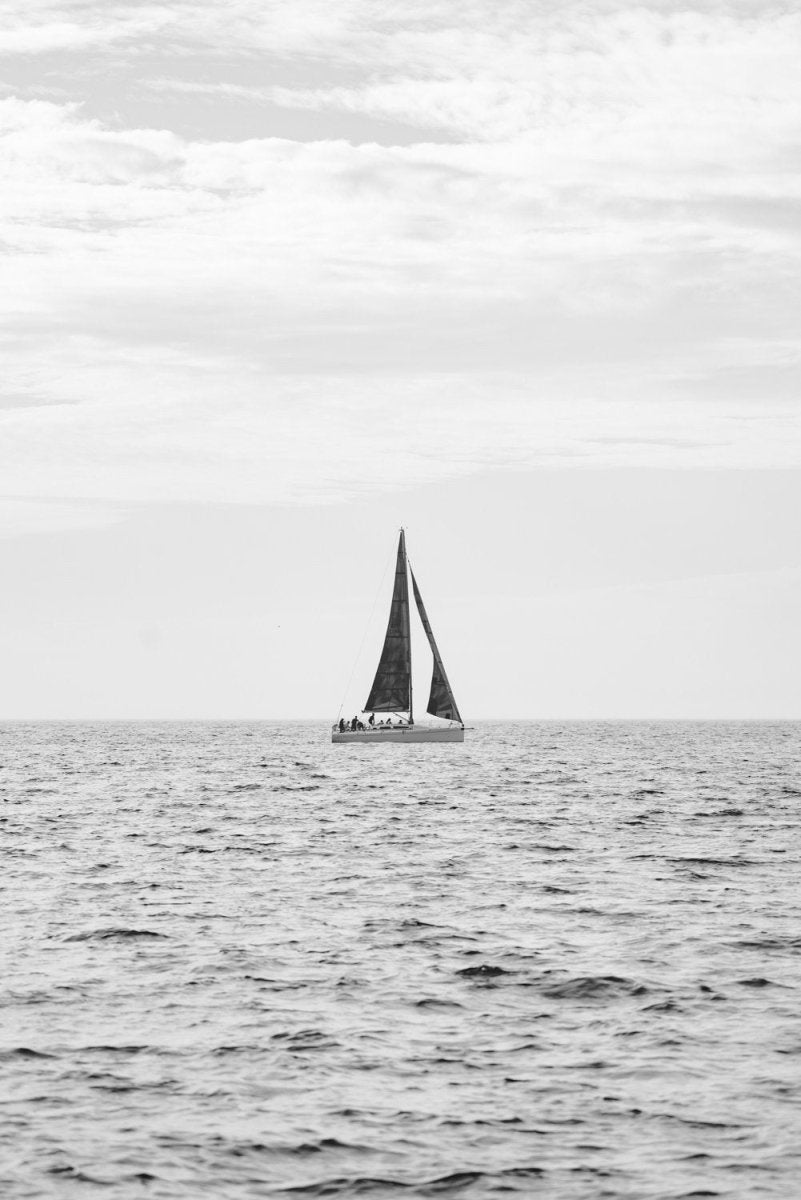 Sailing boat on horizon in black and white