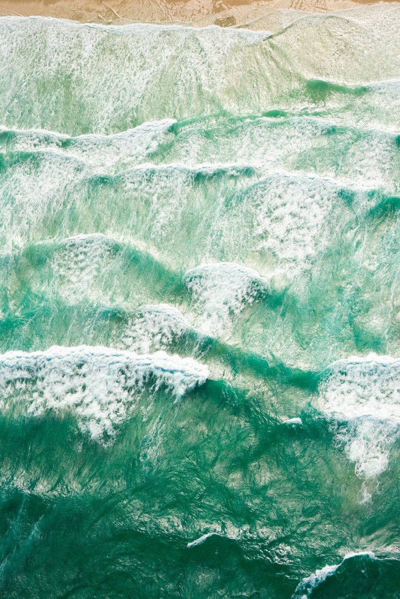 Many waves crashing along Muizenberg beach.