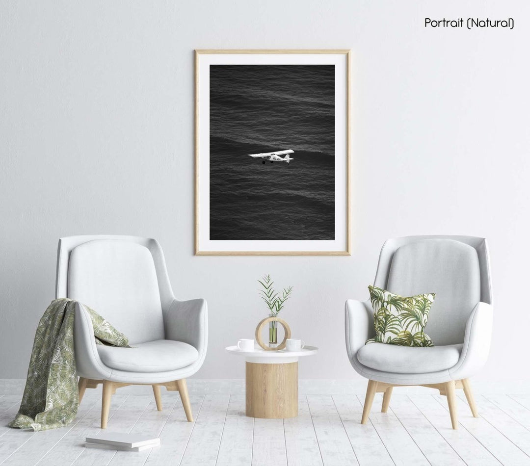 Airplane flying across the ocean at Blouberg Beach in black and white.