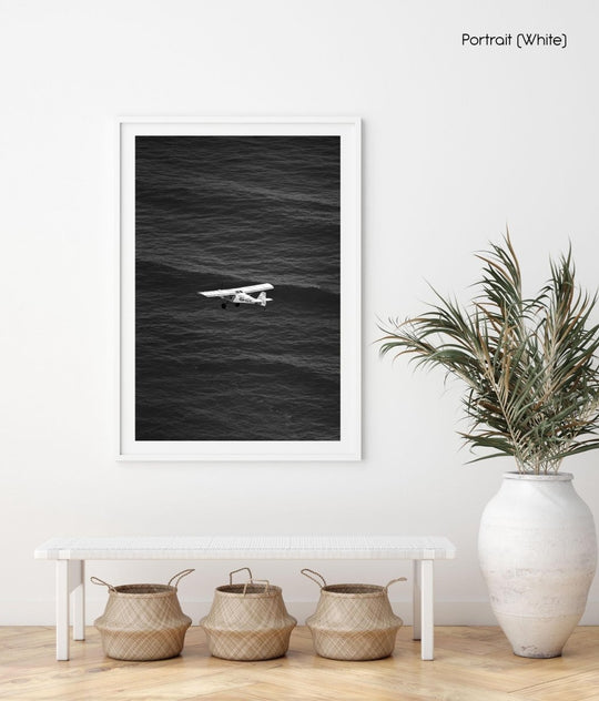 Airplane flying across the ocean at Blouberg Beach in black and white.