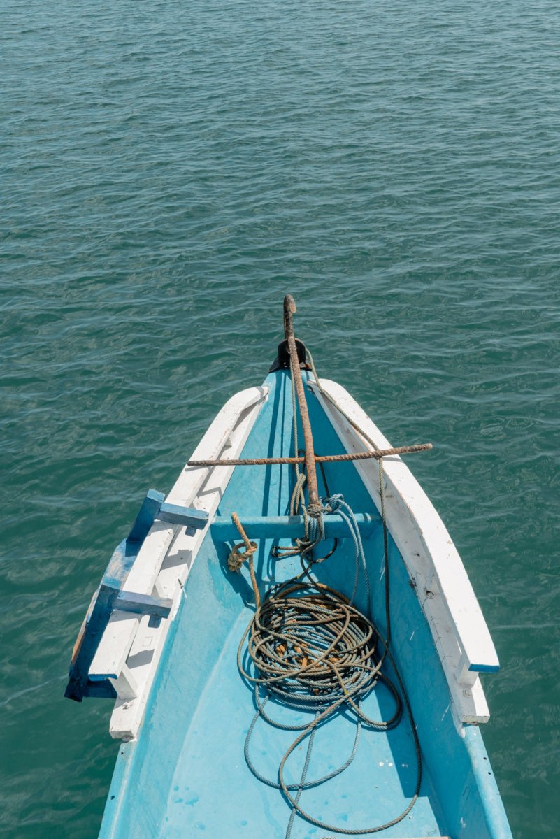Blue boat moving across water in Bali, Indonesia on Lombok island.